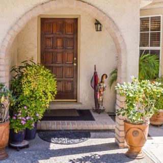 A welcoming entrance with potted plants and an arched doorway.
