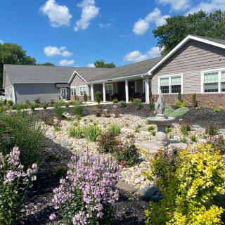 Beautiful single-story house with a well-maintained garden under a bright blue sky.