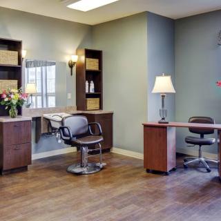 A well-lit salon interior with workstations featuring chairs, mirrors, and elegant decor.