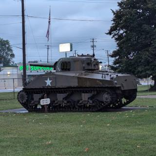 A historic military tank displayed in a park setting.