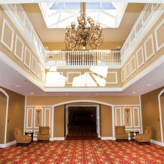 A spacious lobby with a grand chandelier and elegant architectural details.