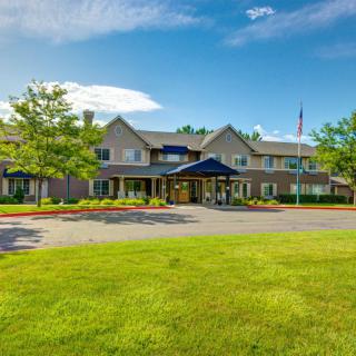 A well-maintained building with a landscaped lawn and clear blue sky.