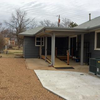 A house with an accessible ramp leading to the porch in the backyard.