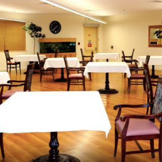 An empty dining area in a restaurant with neatly arranged tables and chairs.