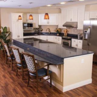A modern kitchen with an island counter and seating area.
