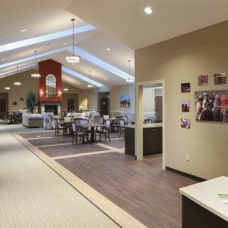 This image shows a spacious and modern interior with a dining area, featuring elegant lighting and skylights.