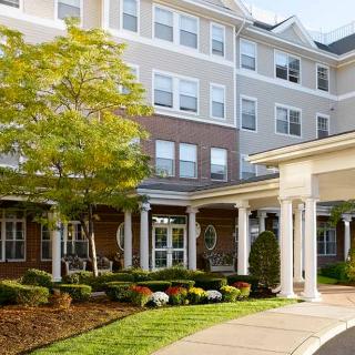 A well-maintained residential building with landscaped surroundings and a covered entrance.