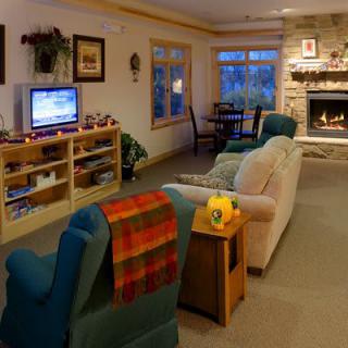 A cozy living room featuring a fireplace, television, and comfortable seating.