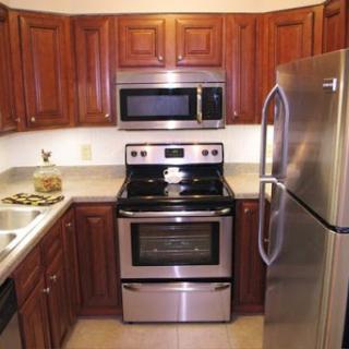 A modern kitchen featuring stainless steel appliances and wooden cabinets.