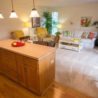 A bright and cozy living space featuring a comfortable seating area and a kitchen island, perfect for relaxation and gatherings.