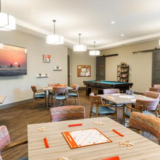 A modern game room featuring a pool table and seating area with contemporary decor.