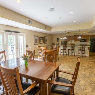 A spacious kitchen and dining area featuring wooden furniture and a bar counter with recessed lighting.