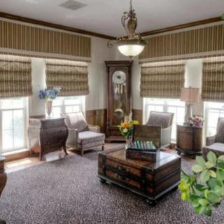 A traditional living room with classic furniture and a grandfather clock.