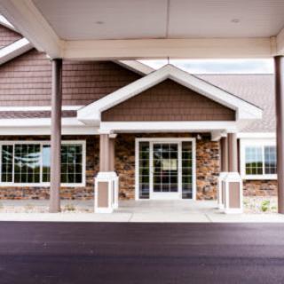 Front entrance of a commercial building with stone facade and large windows.