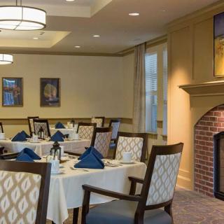 An elegantly designed restaurant dining room with neatly set tables and a cozy fireplace.