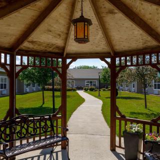 A view from inside a gazebo looking out onto a landscaped garden with a winding pathway.