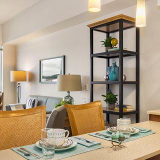 A modern dining area with a neatly set table and stylish shelving in the background.