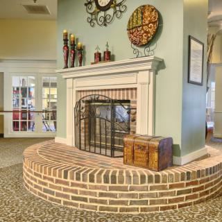 A cozy interior featuring a brick fireplace with decorative items on the mantel.