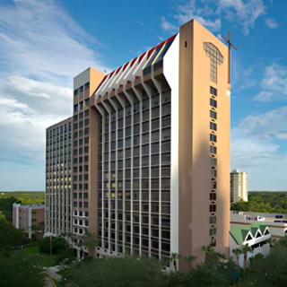 A high-rise hotel building with a modern architectural design set against a clear blue sky.