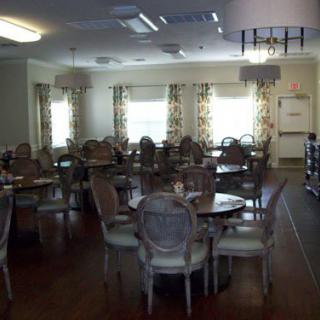 A spacious dining room setup with round tables and upholstered chairs.