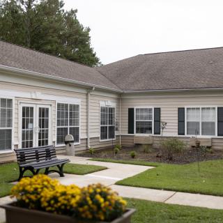 A courtyard area with a bench and flowers outside a residential building.