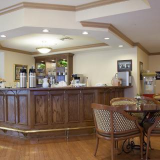 A cozy cafe interior with a wooden bar and seating area.