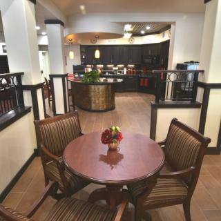A cozy restaurant interior featuring a round wooden table with four chairs.