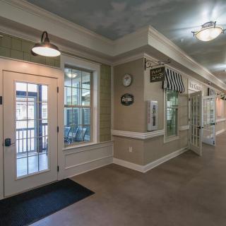 A well-lit hallway with decorative elements, windows, and doors.