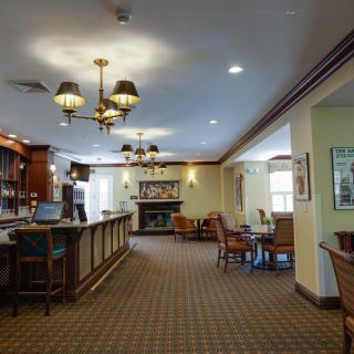 An elegant lobby with a reception desk, seating area, and a fireplace.