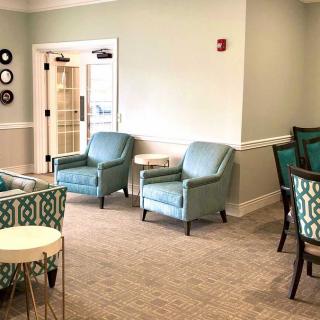 A modern seating area with comfortable chairs and tables in neutral tones.