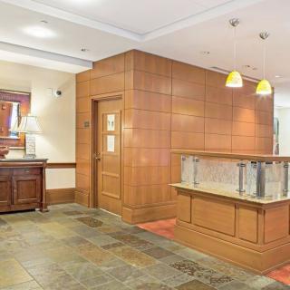 A modern lobby with wood paneling and warm lighting.