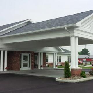 A building entrance with a covered driveway and white columns.