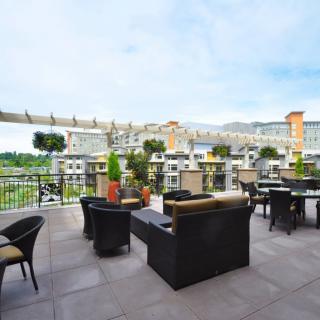 A stylish rooftop terrace with outdoor seating and a scenic city view.