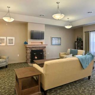 A cozy living room with comfortable seating, a fireplace, and a mounted television.