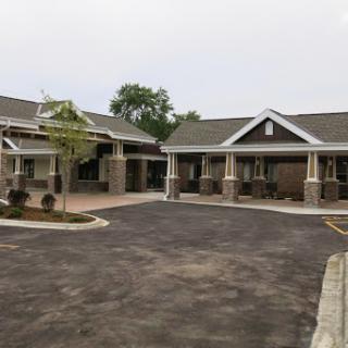 A view of a modern residential building with an adjoining parking area.