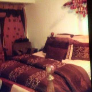 A cozy bedroom featuring a beautifully made bed with rich, warm-toned bedding.