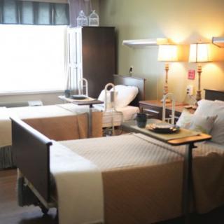 A hospital room with two beds and medical equipment.