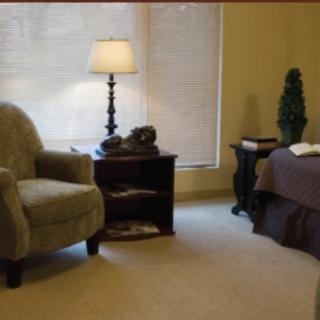 A cozy living room with an armchair, side table, and lamp.