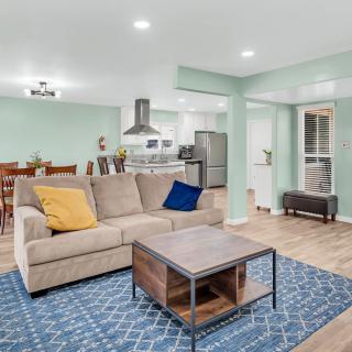 A modern open floor plan living area featuring a cozy sofa, coffee table, and dining space with a view into the kitchen.