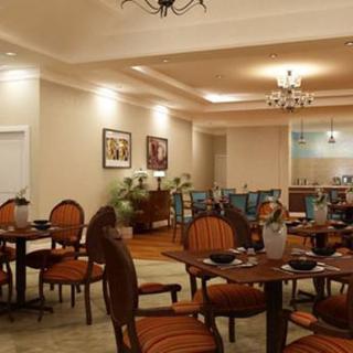 A cozy and elegant dining room with warm lighting, featuring classic furniture and neatly set tables.