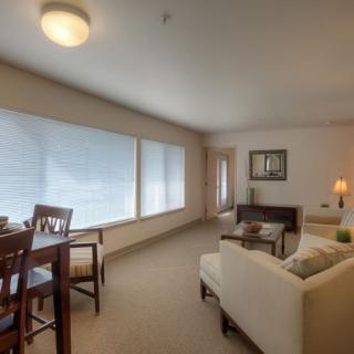 A cozy and bright living room with modern furniture and large windows.
