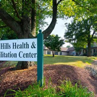 Welcome to Hills Health & Rehabilitation Center, a serene facility surrounded by greenery.