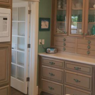 A cozy kitchen featuring wooden cabinets and a glass-paneled door.