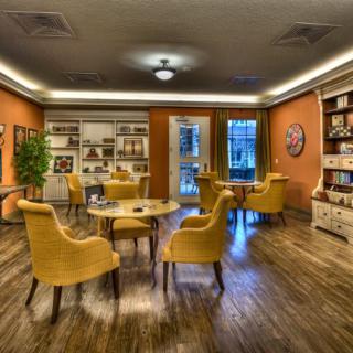 A cozy library interior with yellow chairs and bookshelves.