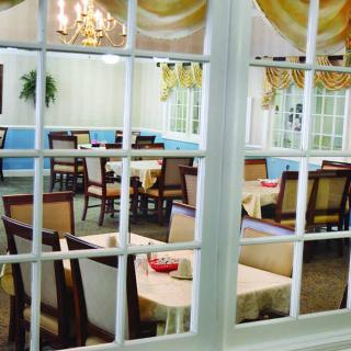 A cozy dining room with elegant furniture, seen through a window.