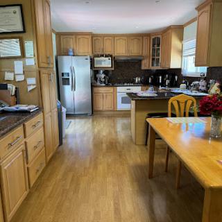A cozy and modern kitchen featuring wooden cabinets, stainless steel appliances, and a dining area.