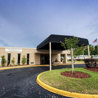 A building with a covered entrance and landscaped surroundings.