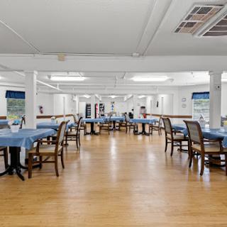 A spacious dining area with neatly arranged tables and chairs.