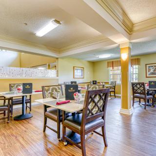 A well-organized dining area with neatly arranged tables and chairs, featuring warm lighting and stylish decor.
