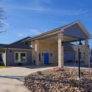 A modern house with a driveway under a clear blue sky.